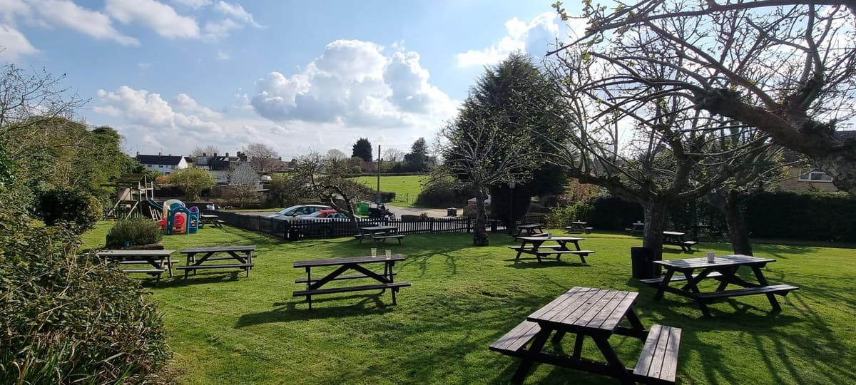 Picnic benches and lawn in the garden at The Overstone Arms