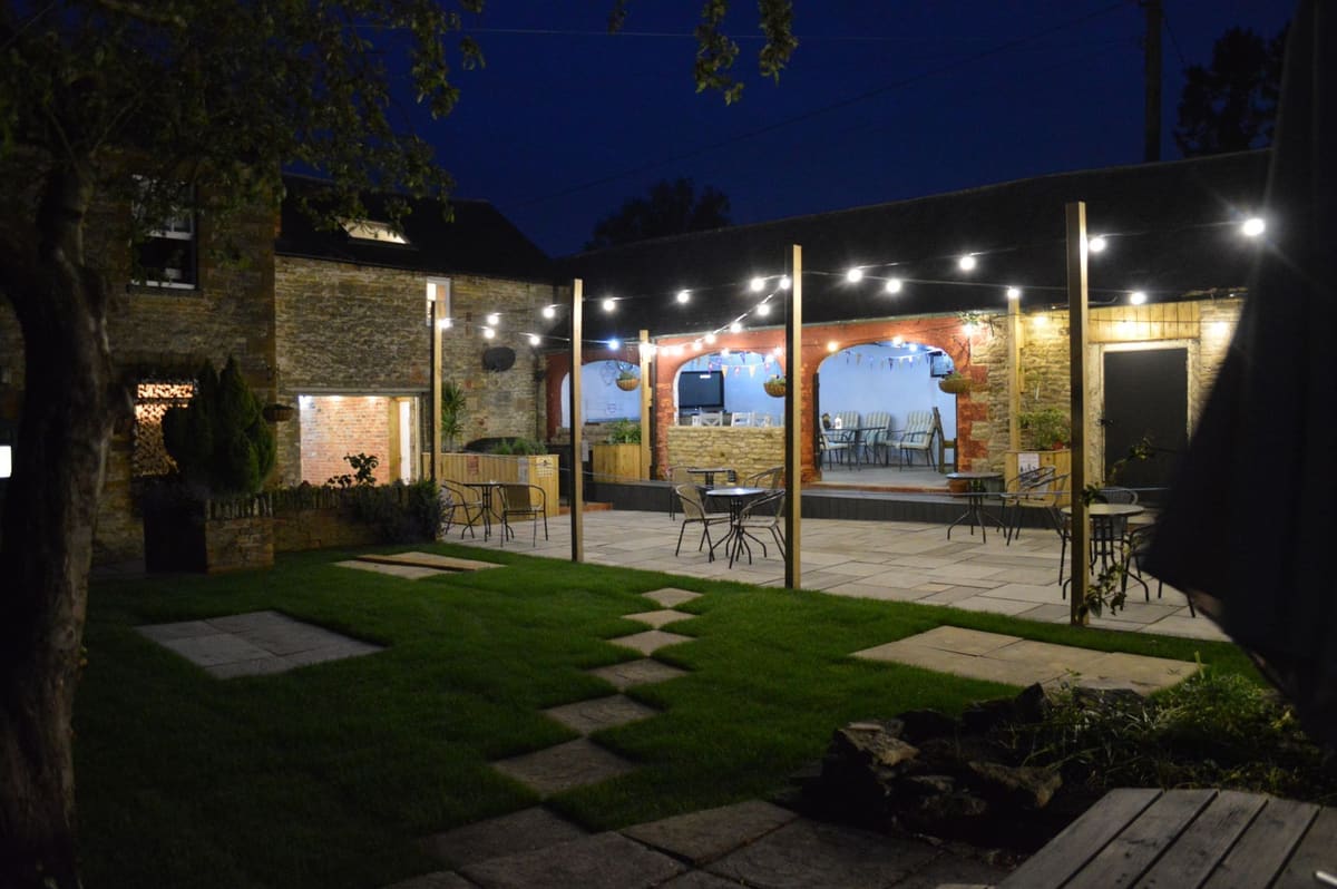 The Secret Garden at The Overstone Arms, lit up in the evening